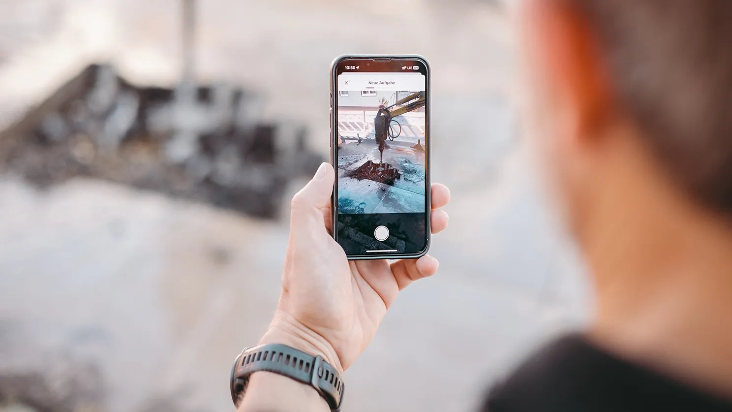 Mann macht ein Foto mit der ToDo-App von einer Aufgrabung und erstellt eine neue Aufgabe